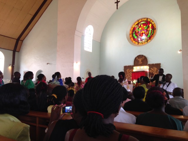 The St. Peter Choir of St. Augustine Church, Makerere University, processes towards the altar carrying gifts of Thanksgiving