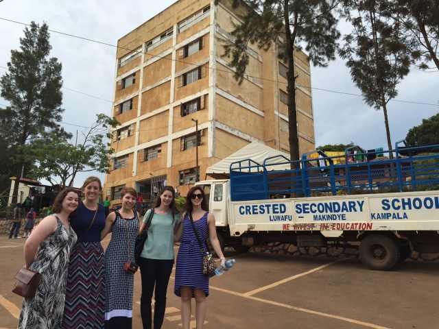 The large building behind the girls is the main school building housing both classrooms and a dormitory.