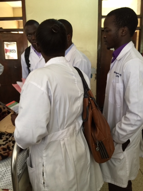 4th Year students at the bedside of a patient at Mulago Hospital as they interview the patient to learn about the medications the patient was on at home. 