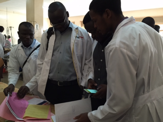 4th Year students consult with each other while they review a patient's medical record at Mulago Hospital